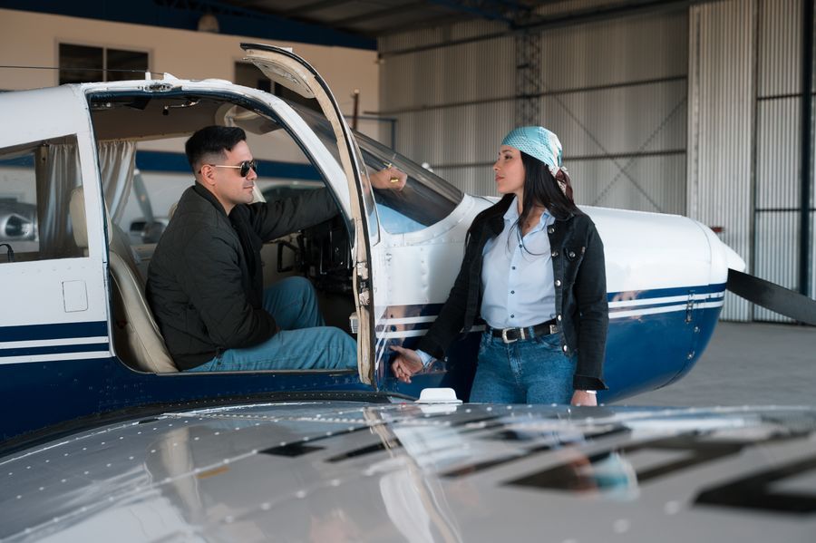 An instructor and student talking beside a training aircraft